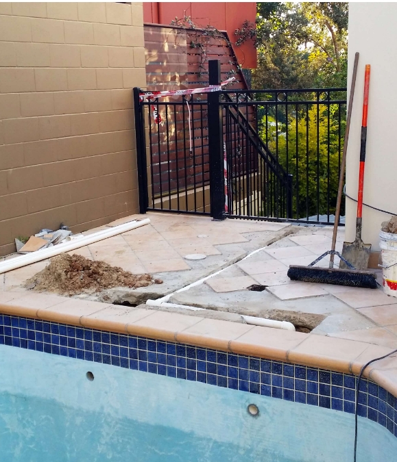 A pool being repaired with a ladder and debris.